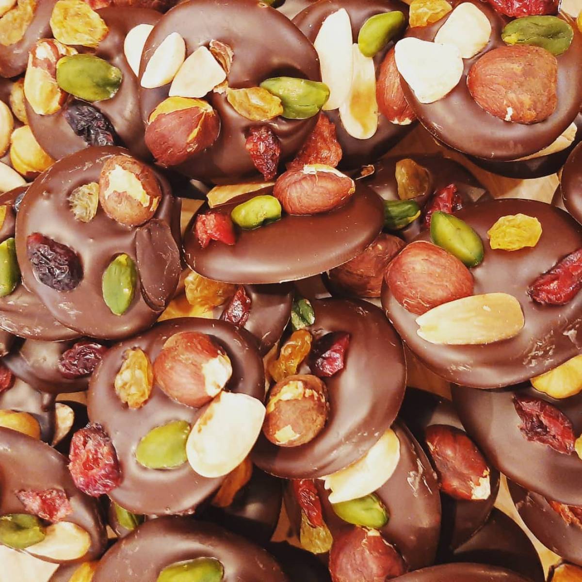 Les mendiants, palets de chocolats noir 70% surmontés de fruits secs.